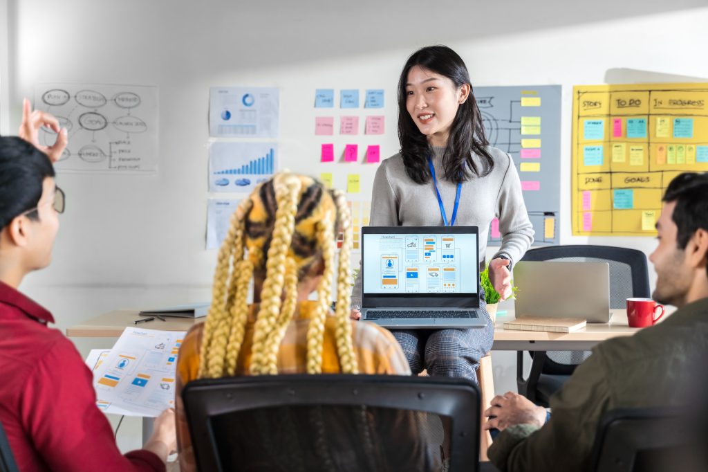 Asian female creative designers present ux UI to team.designers team working meeting in a modern off