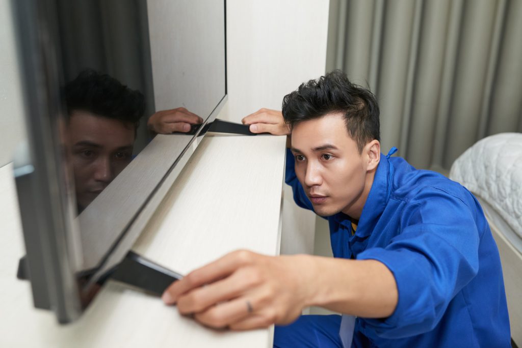 Worker putting tv set on console