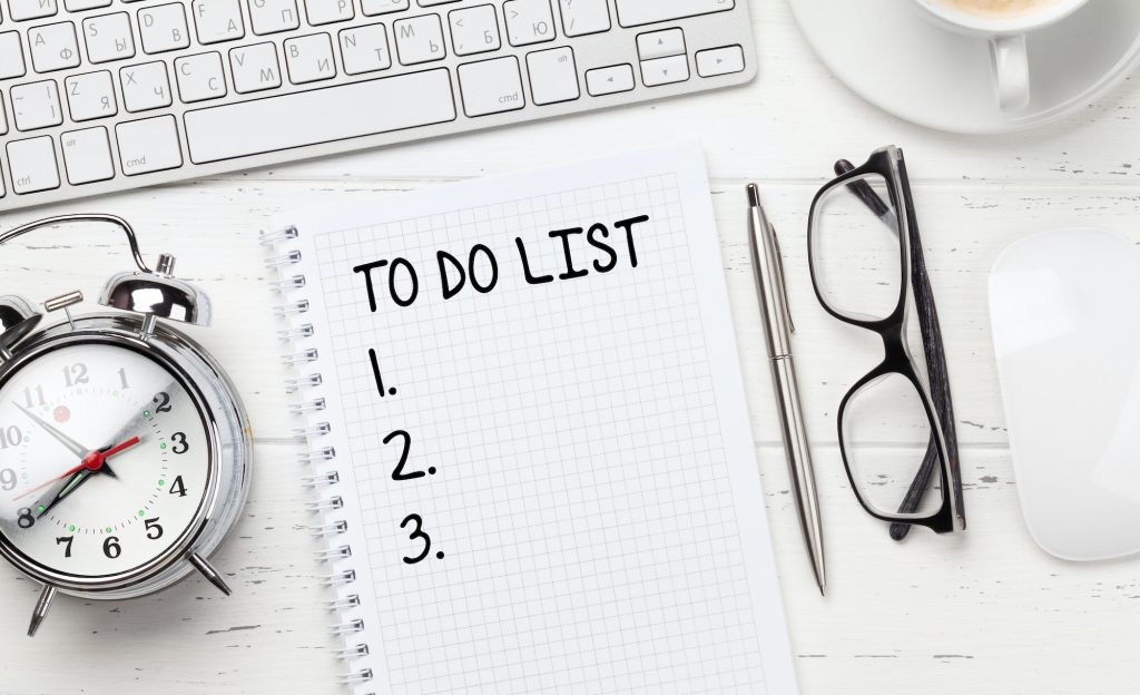 Workplace with to do list, supplies and alarm clock